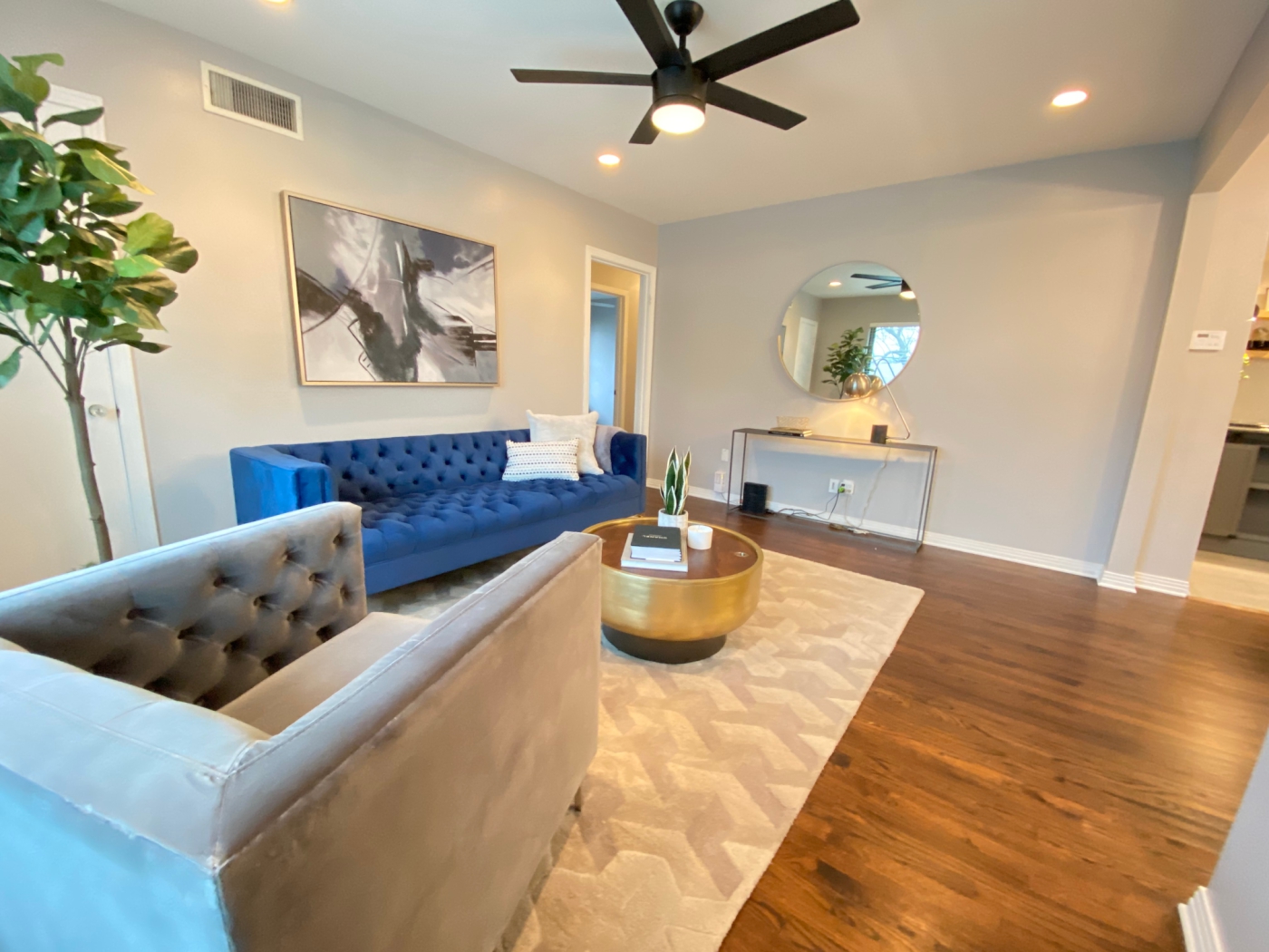 A living room with a blue velvet couch