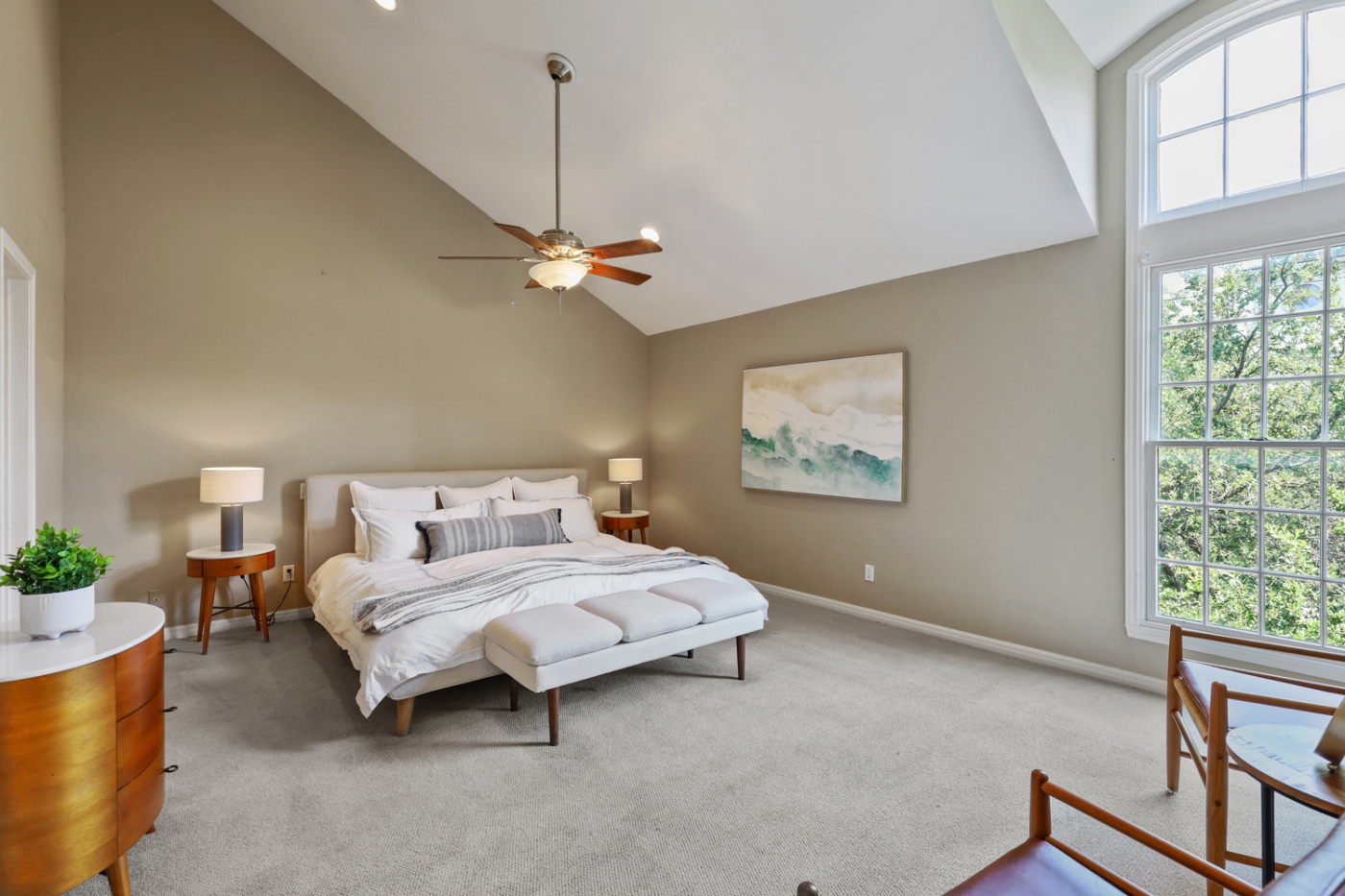 A bedroom with a slanted roof and large windows